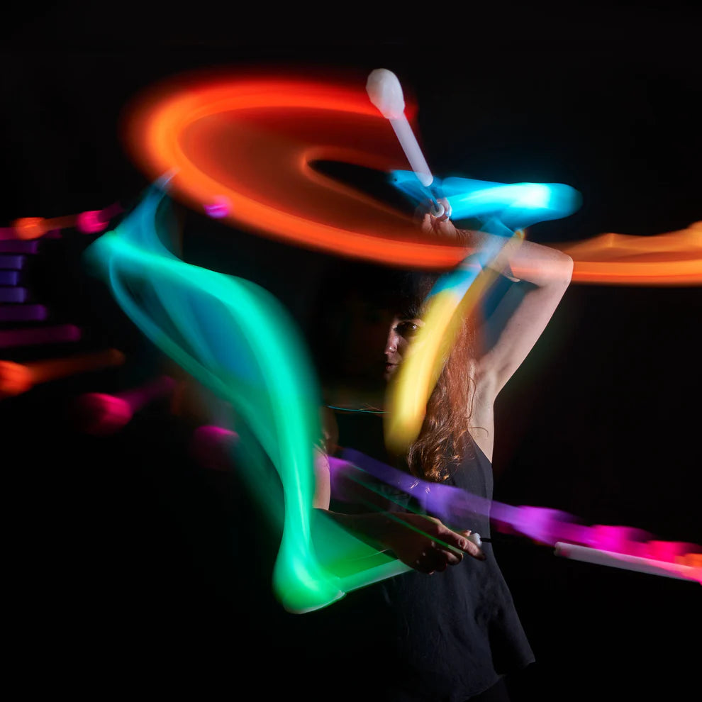 Person performing with colorful LED nunchucks on a dark background