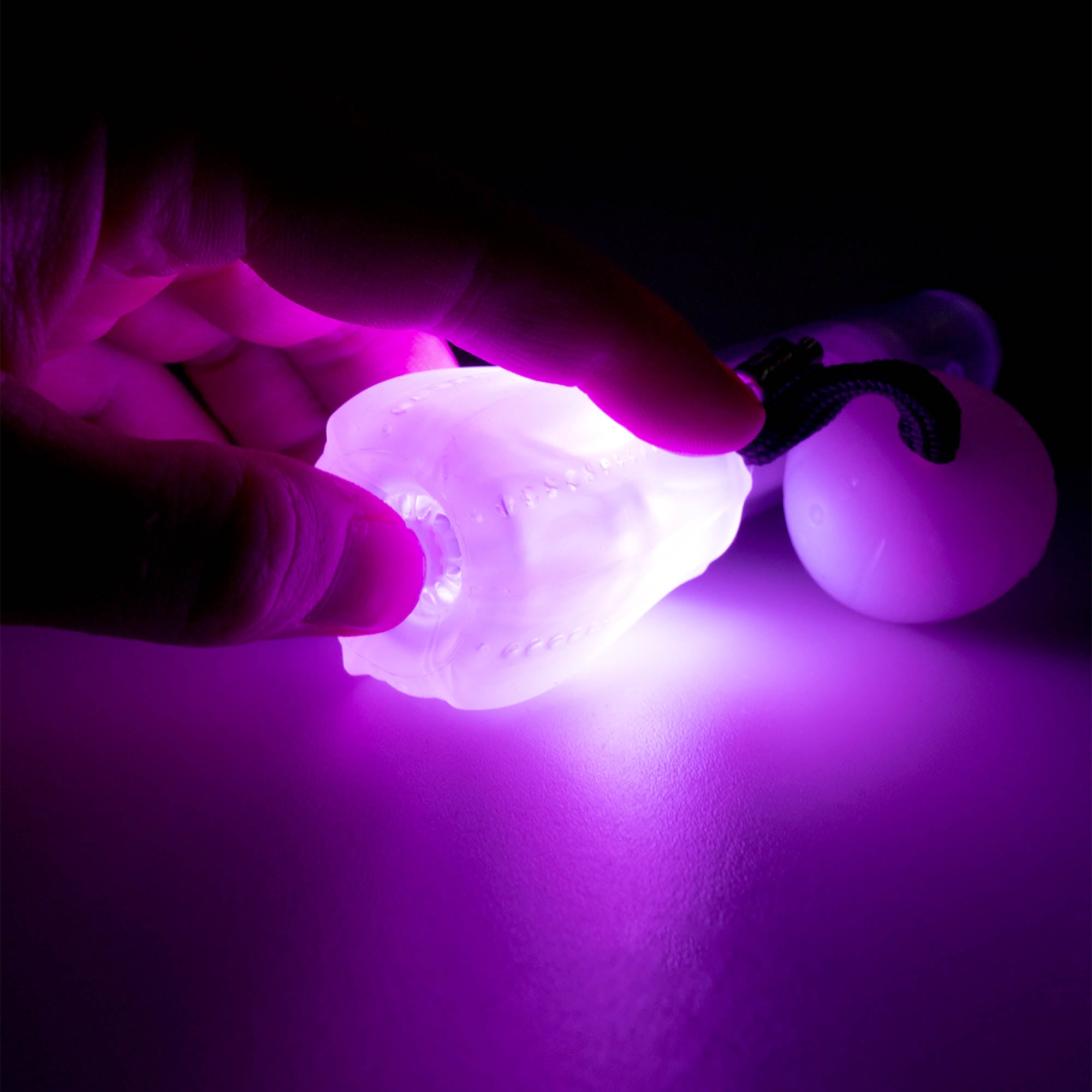 Flowtoys composite contact wand v2 close up pressing button at the end of the wand of wand end, whilst glowing