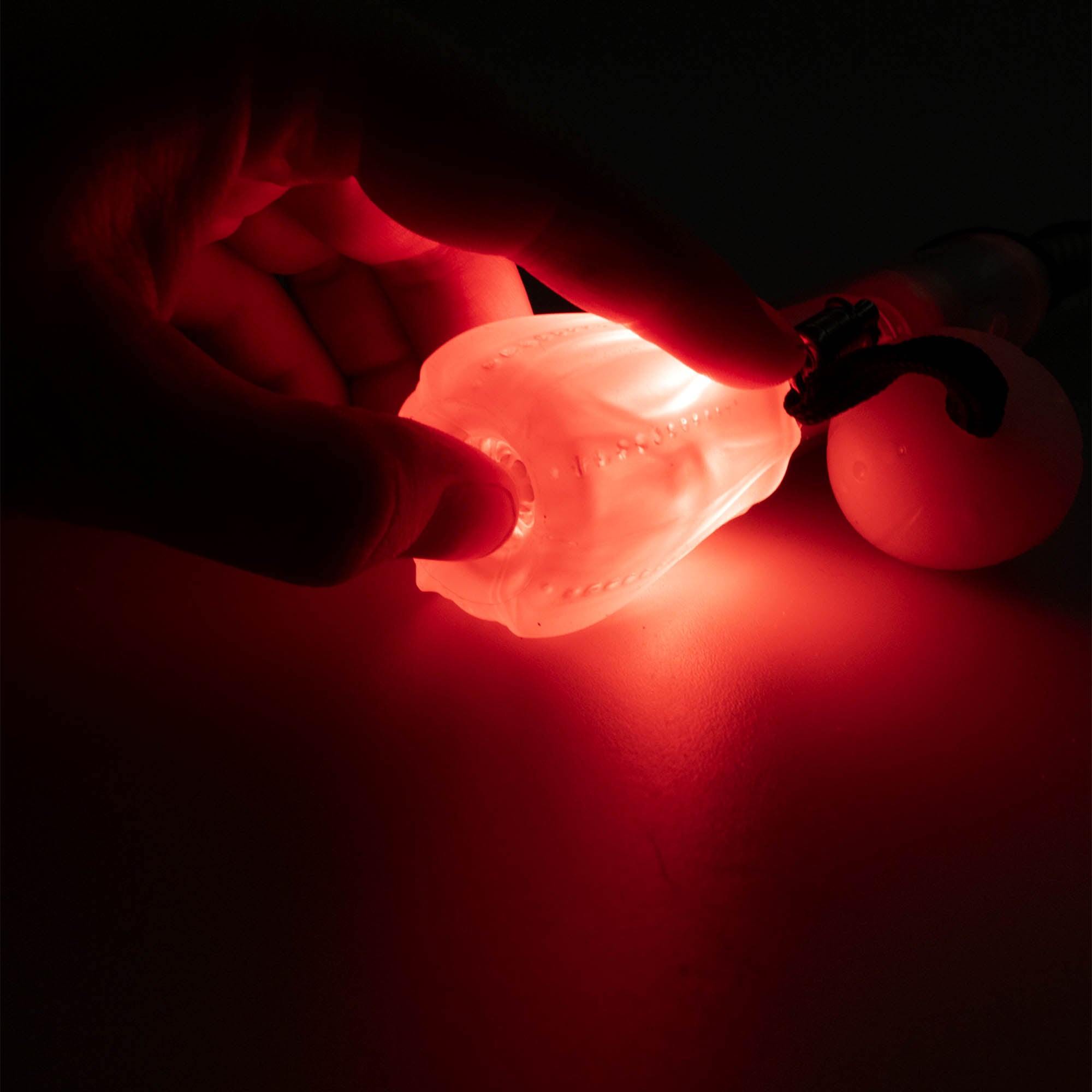 Flowtoys composite contact wand v2 close up pressing button at the end of the wand of wand end, whilst glowing