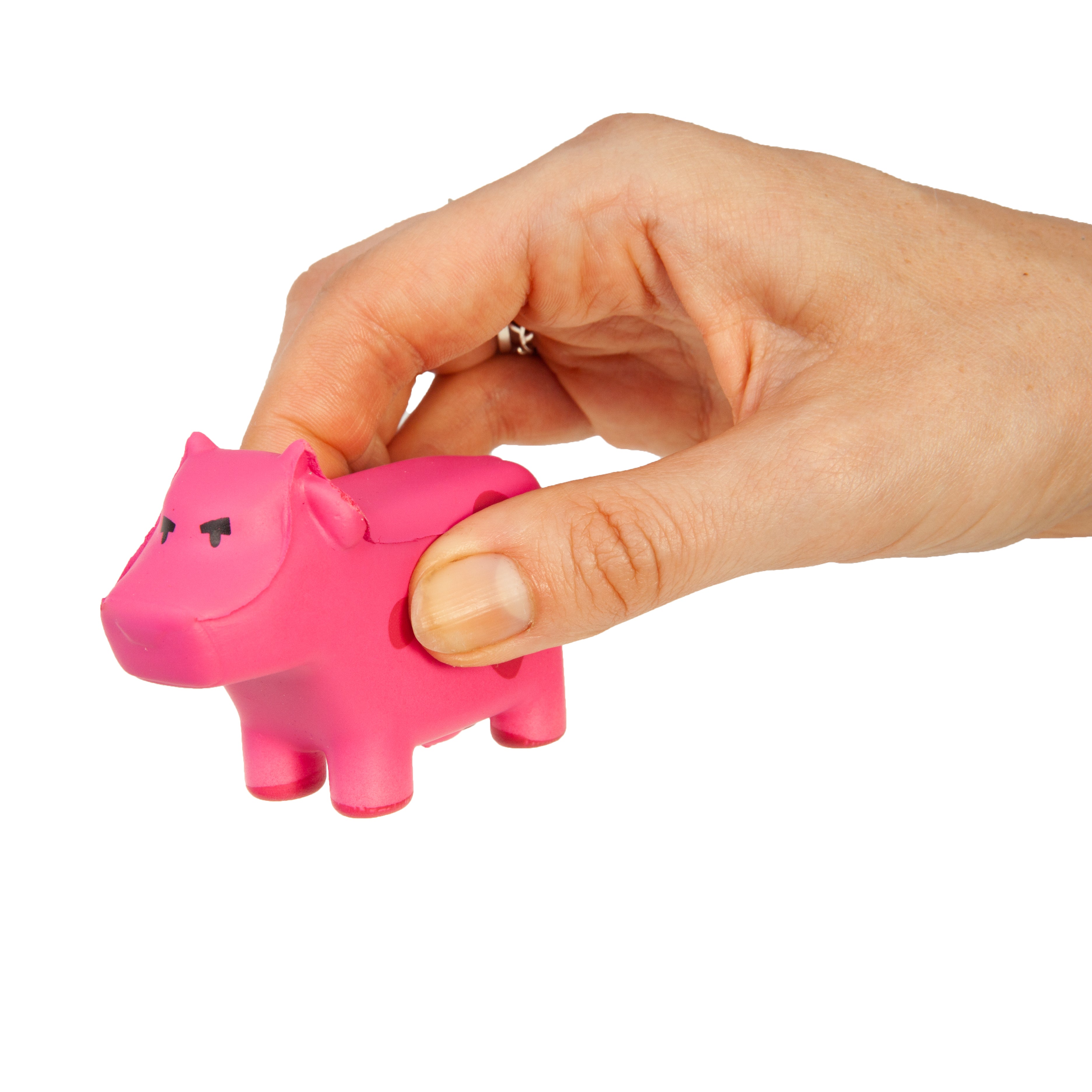 Hand holding a pink cow shaped figureine against a white background