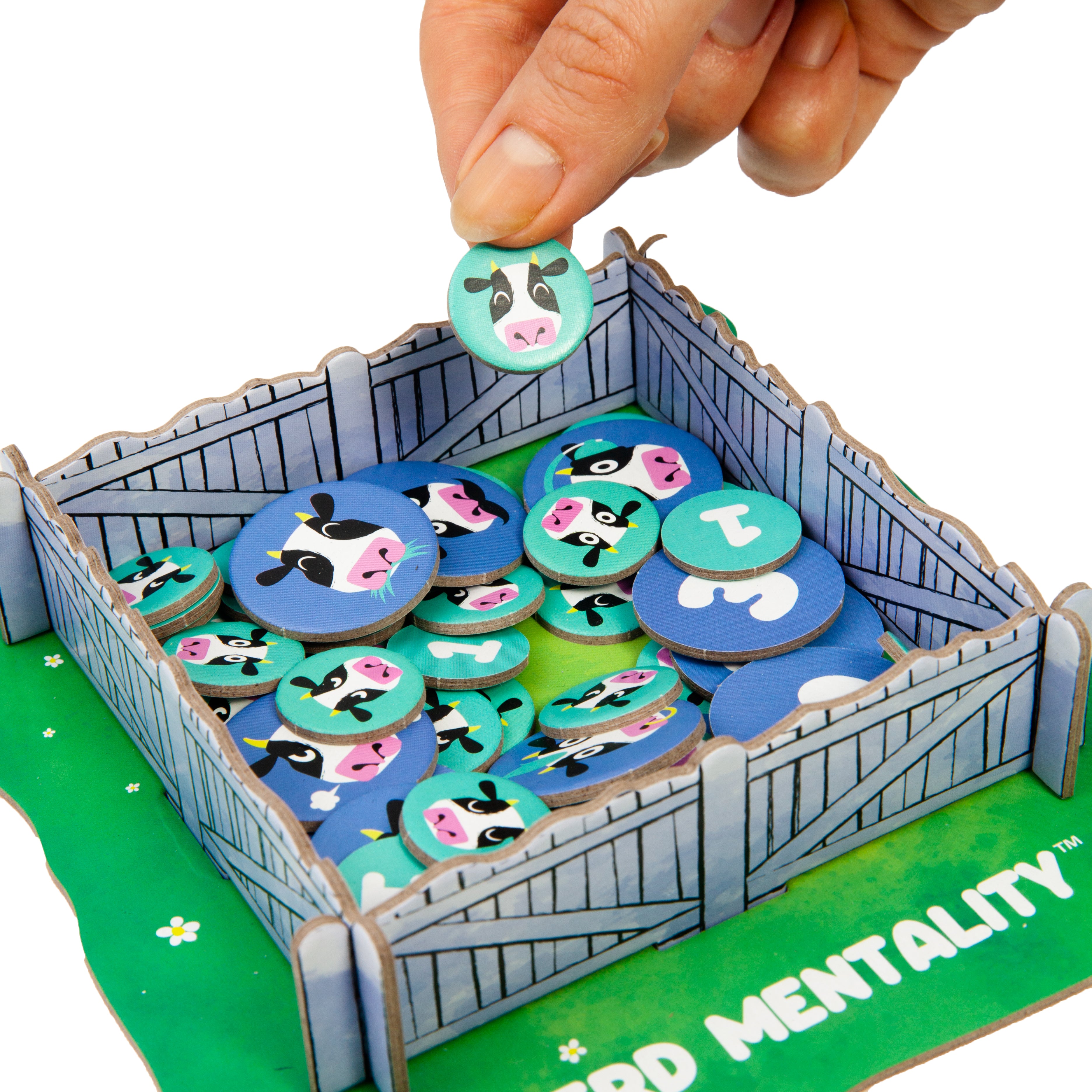 Board game component with cow-themed tokens in a cardboard barn setup