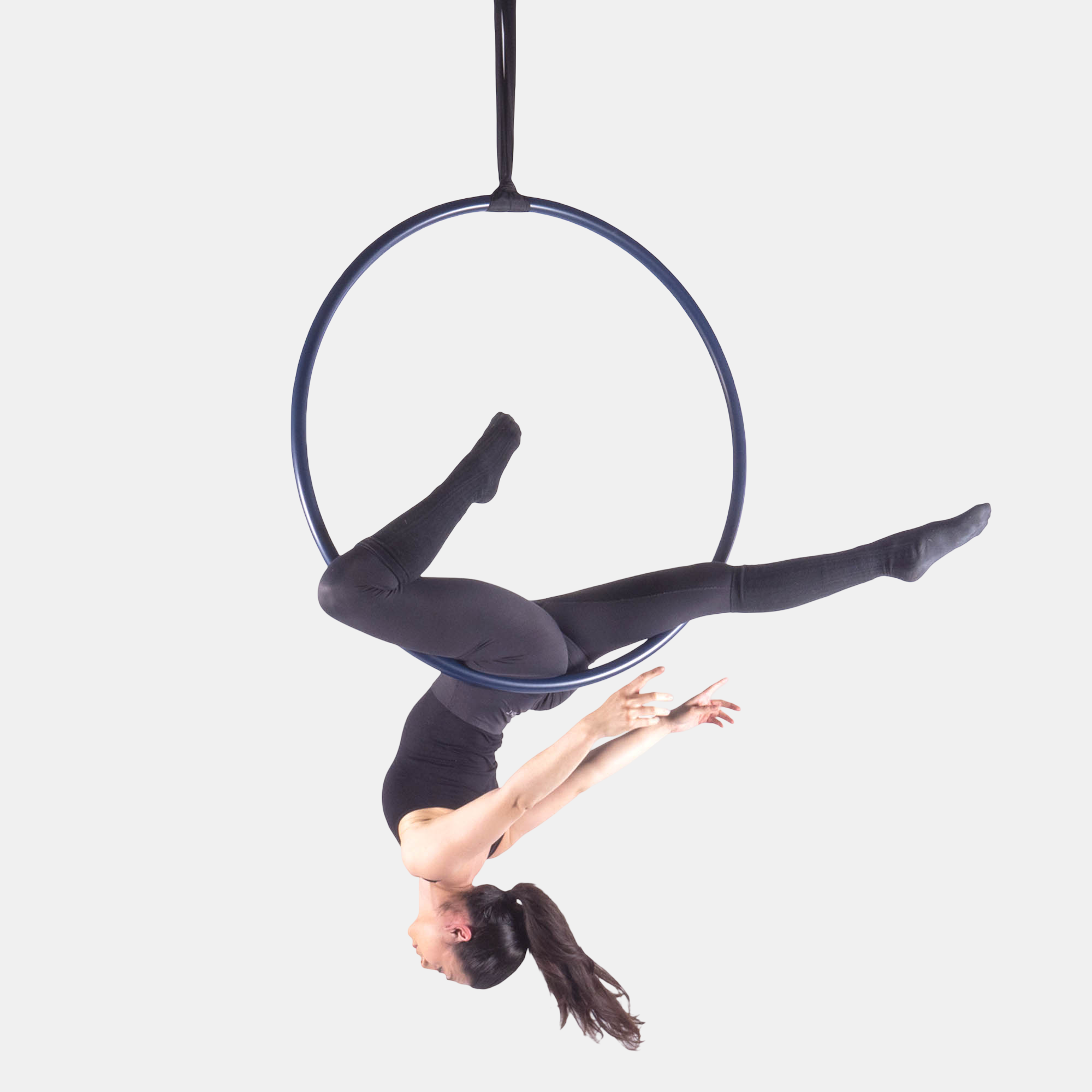 Person performing aerial acrobatics on a hoop against a white background