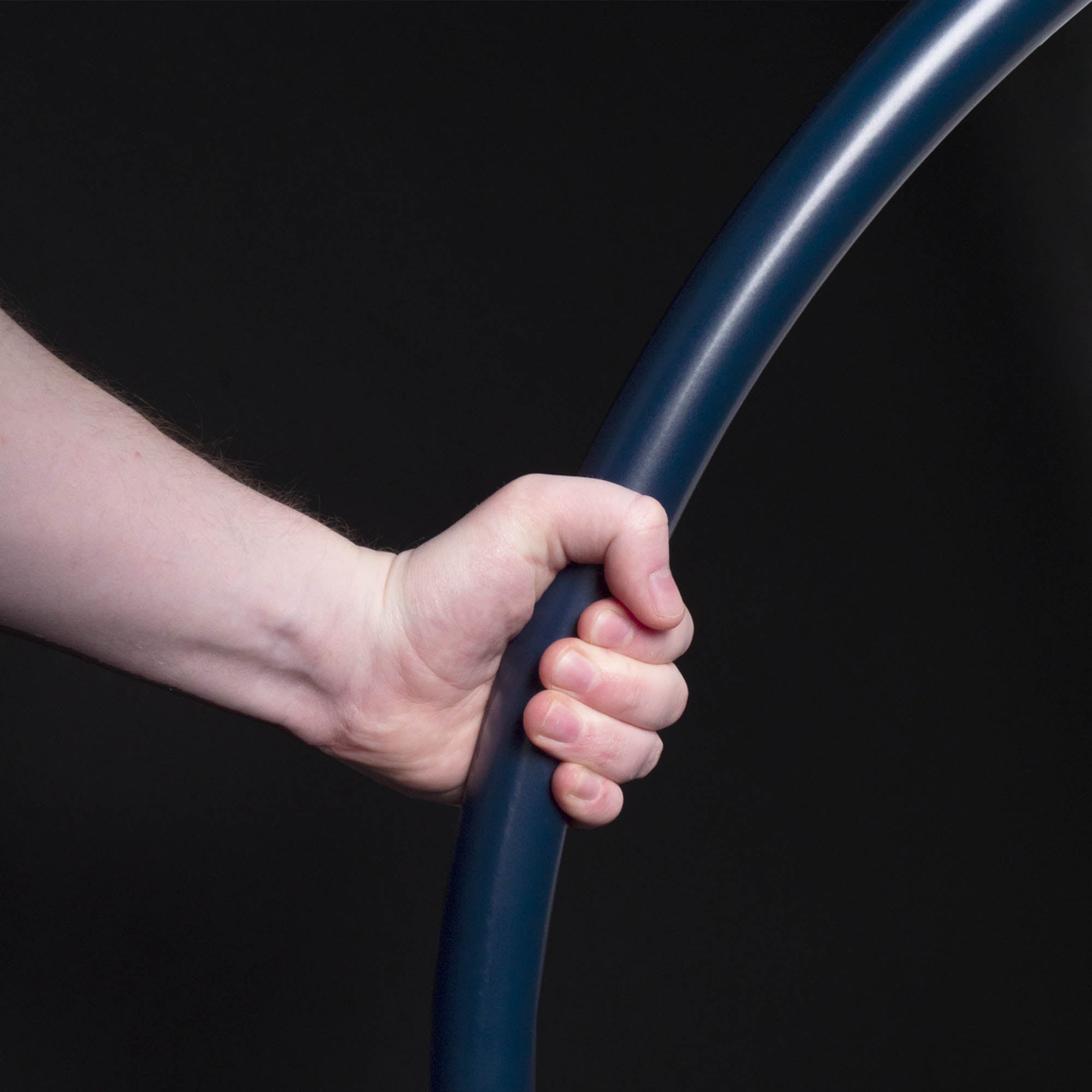 Hand gripping blue hoop on black background