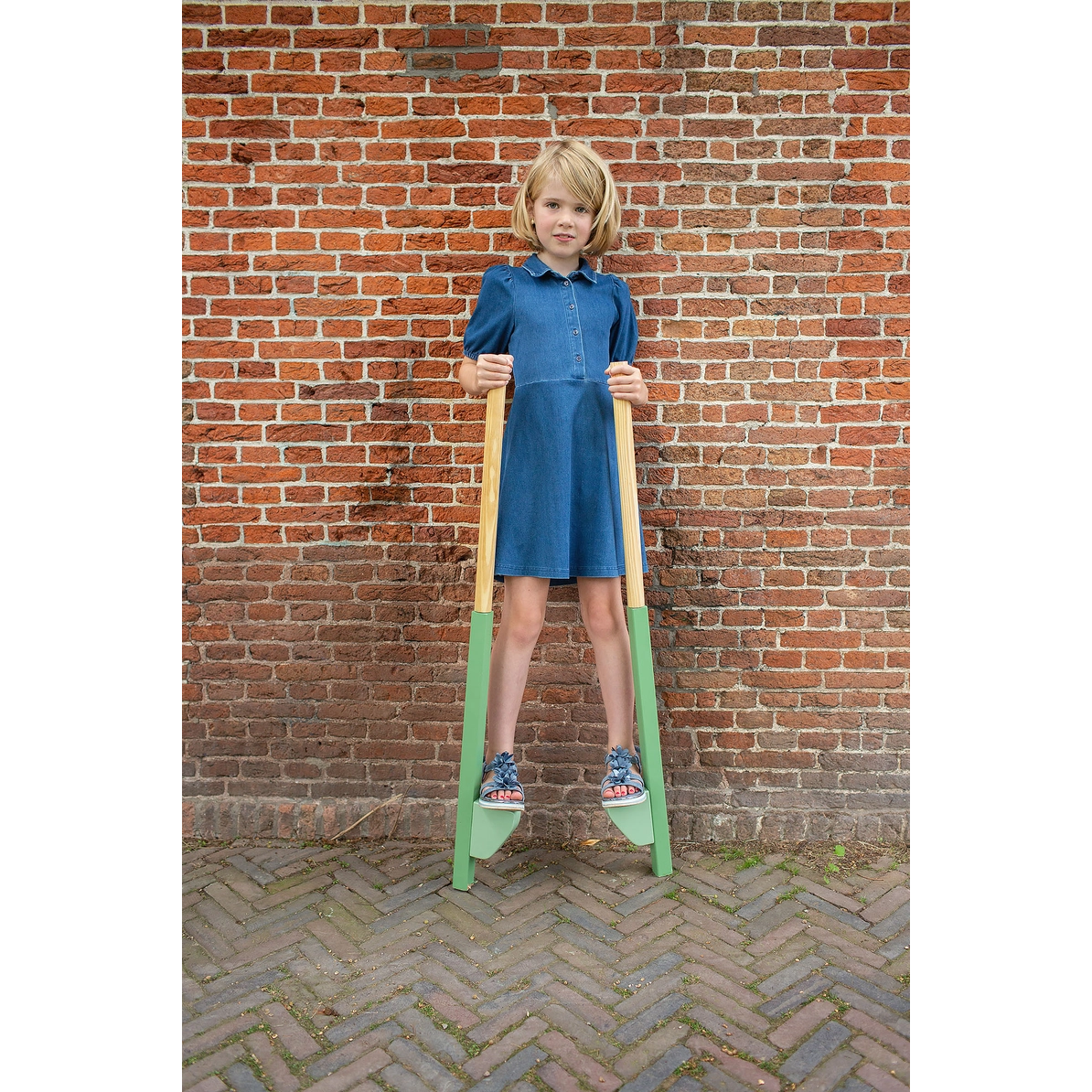 Child standing on wooden stilts
