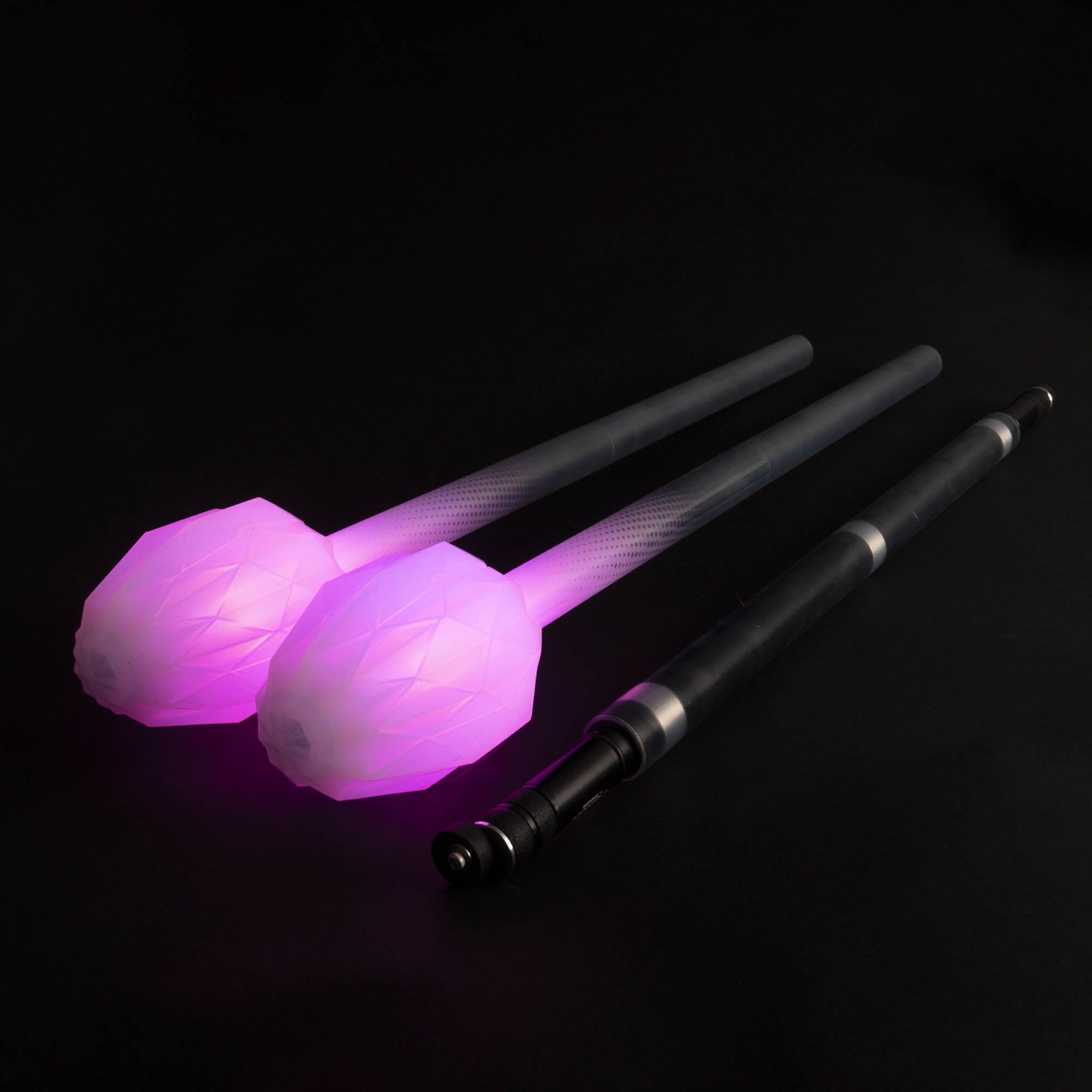 A handle and two LED ends with glowing pink tips on a black background