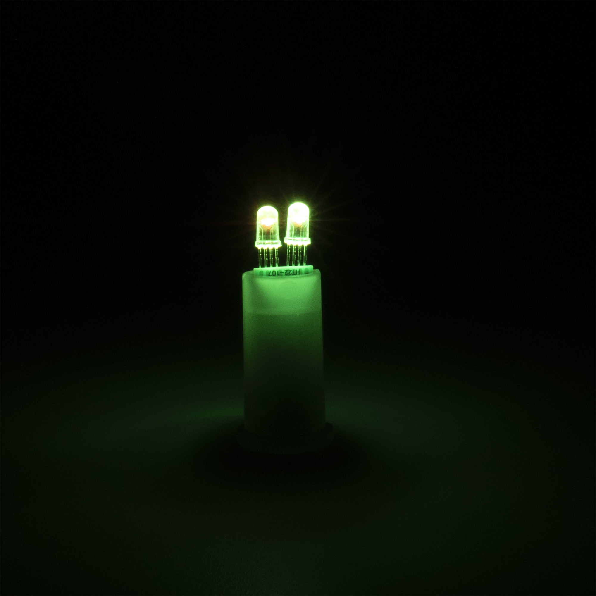 Green LED light bulb on a black background