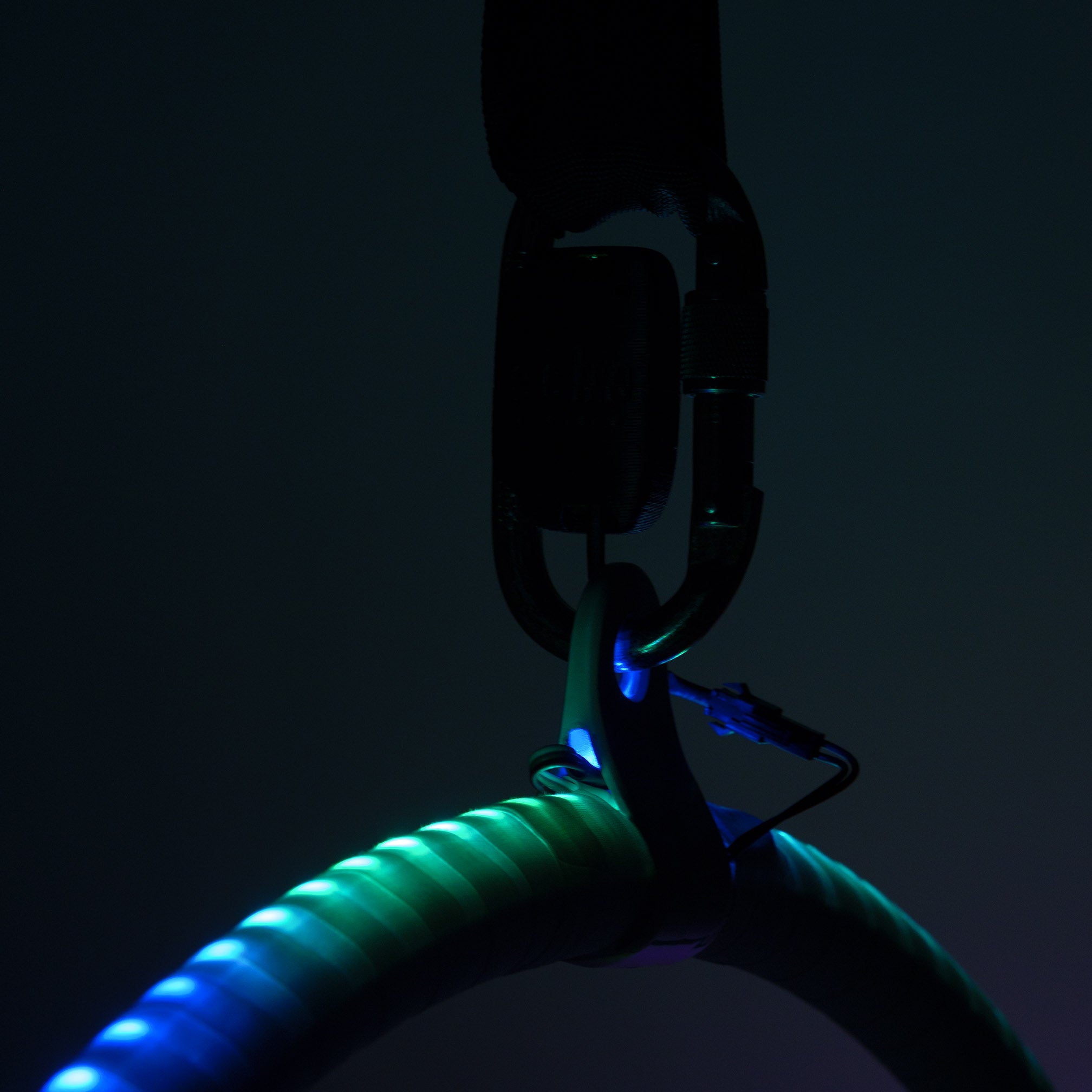 Low light, glow on hoop and silloutte of the carabiner and battery