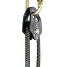 Petzl rescue pulley in black attached to carabiner at angle